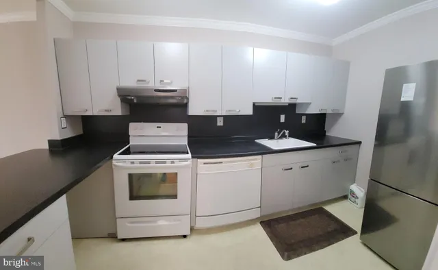 a view of a living room with kitchen countertops and wooden floor