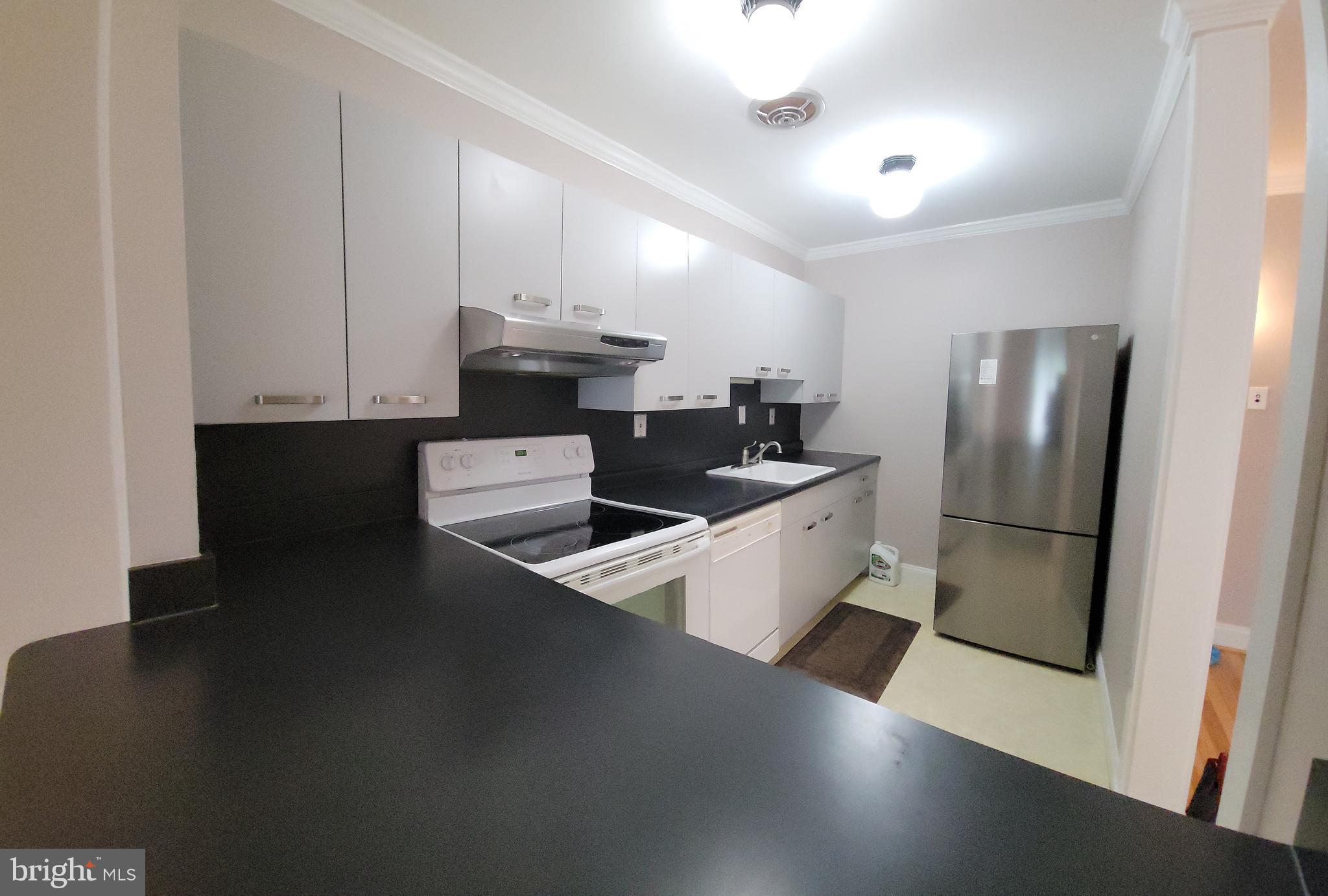46 Township Line Road, Unit 305 Elkins Park, PA 19027 - Photo 15 of 31 a kitchen with stainless steel appliances a refrigerator a sink a stove and white cabinets