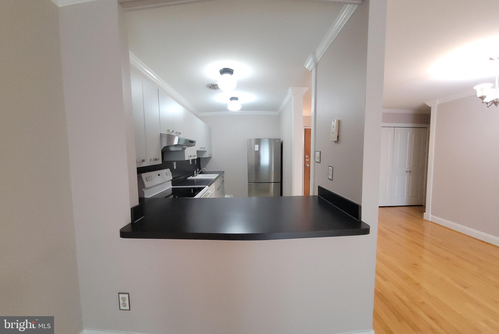 46 Township Line Road, Unit 305 Elkins Park, PA 19027 - Photo 16 of 31 a view of a living room with kitchen countertops and wooden floor
