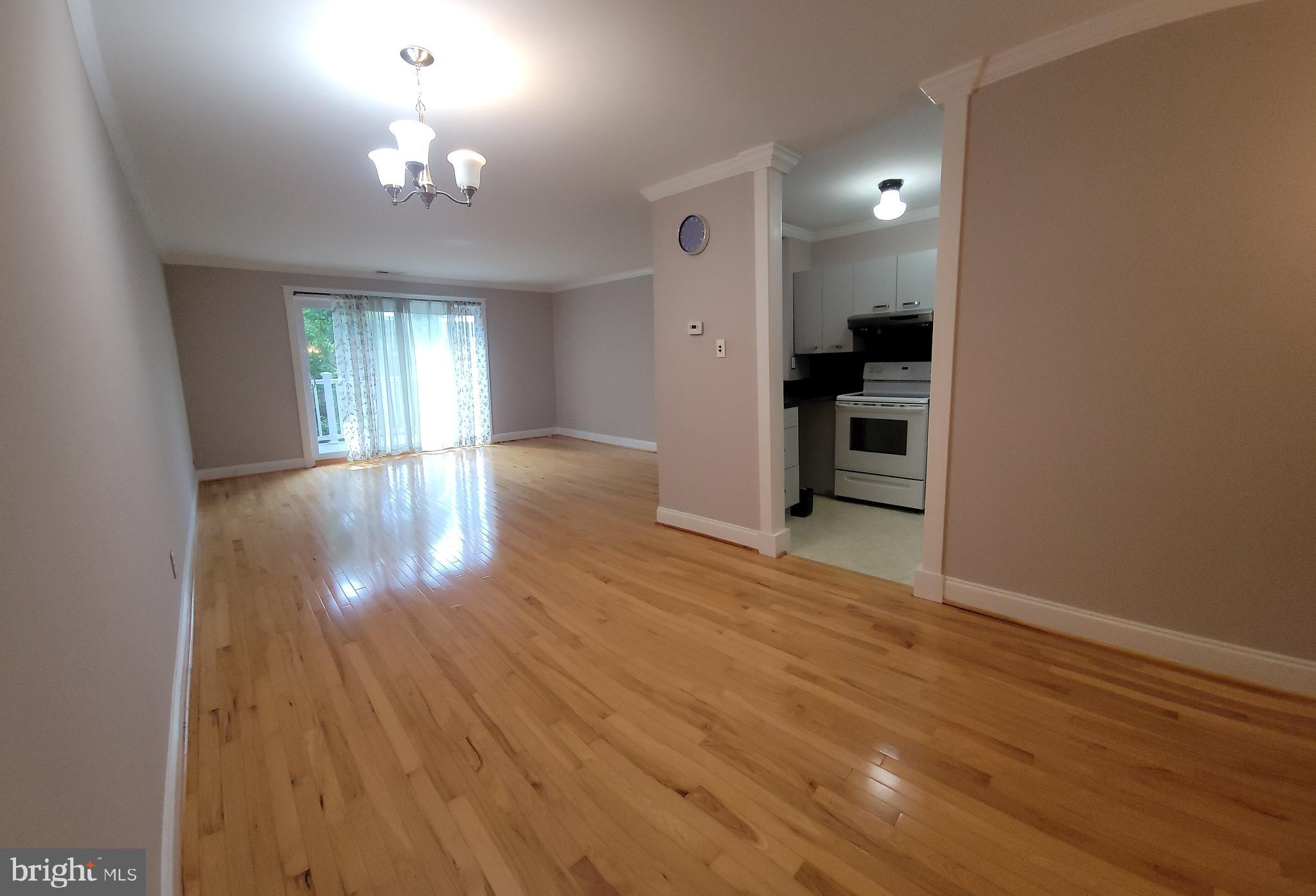 46 Township Line Road, Unit 305 Elkins Park, PA 19027 - Photo 9 of 31 a view of empty room with wooden floor and kitchen
