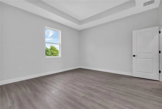 an empty room with wooden floor and a window