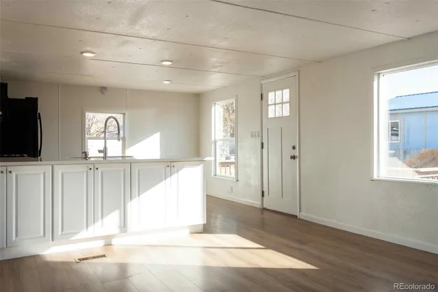 a view of a hallway with wooden floor and windows