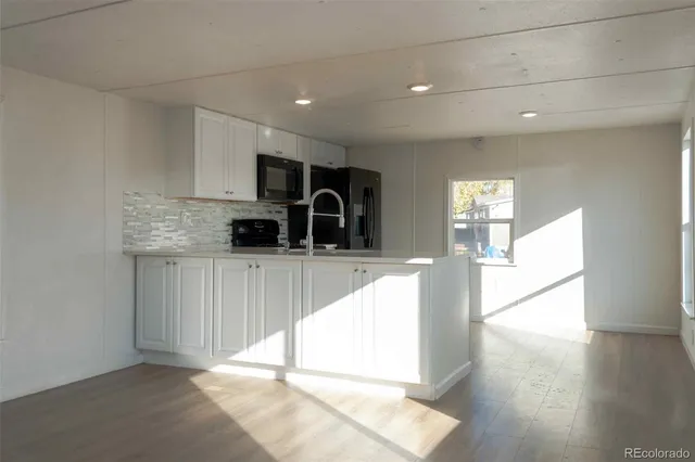 a kitchen with granite countertop a stove a sink and a refrigerator