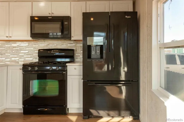 a kitchen with a refrigerator and a stove top oven