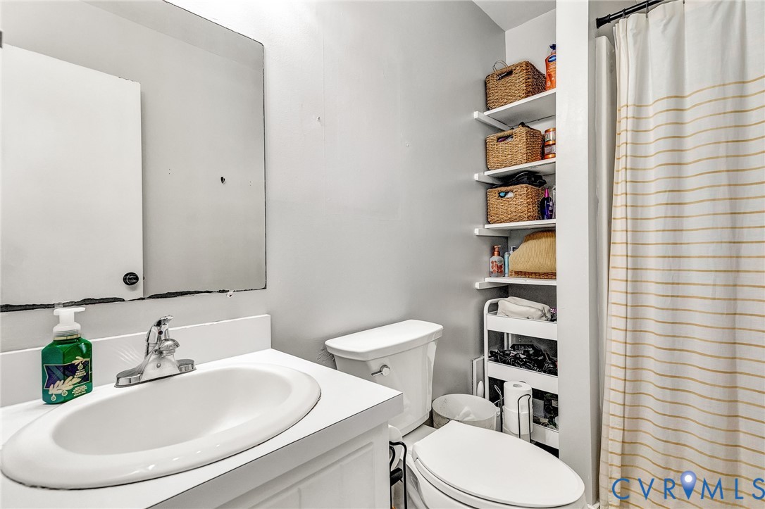 6377 Sledds Lake Road Mechanicsville, VA 23111 - Photo 13 of 15 a bathroom with a sink a toilet and a mirror