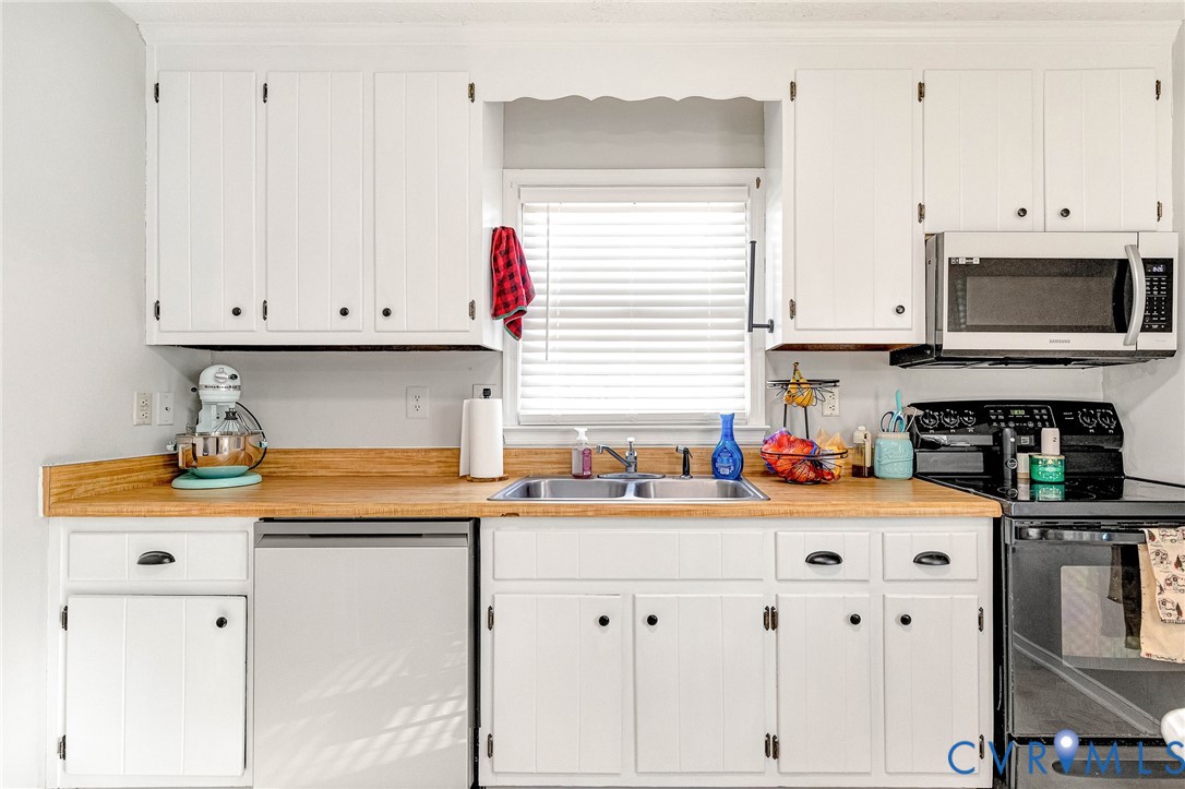 6377 Sledds Lake Road Mechanicsville, VA 23111 - Photo 6 of 15 a kitchen with stainless steel appliances granite countertop a sink a stove and white cabinets