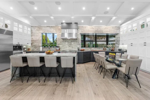 a dining area with stainless steel appliances a dining table chairs and wooden floor