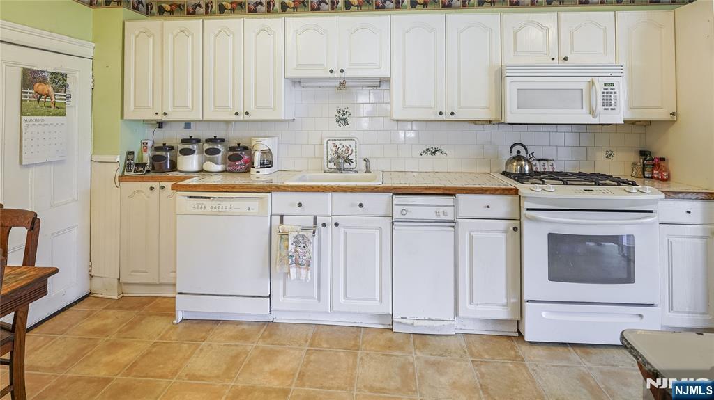 695 Ramapo Valley Road Oakland, NJ 07436 - Photo 15 of 42 a kitchen with granite countertop cabinets and white appliances