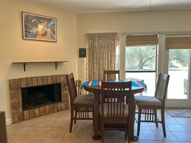 a dining room with furniture a fireplace and wooden floor