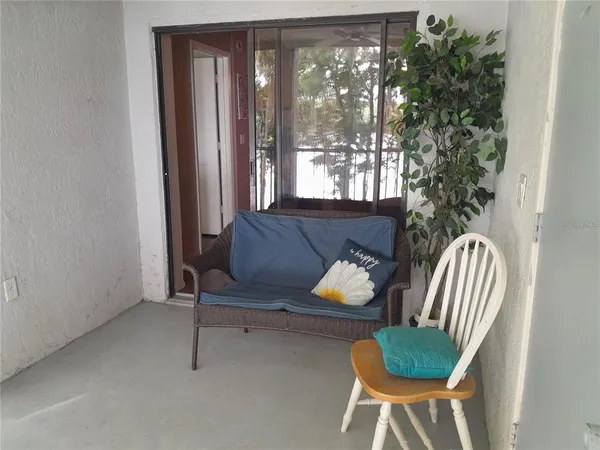 a view of a backyard with table and chairs potted plants and a fountain