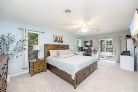 a spacious bedroom with a large bed and a chandelier