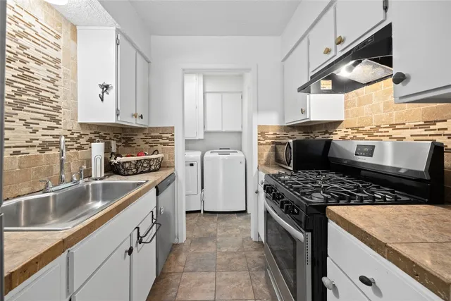 a kitchen with granite countertop a sink stove and refrigerator