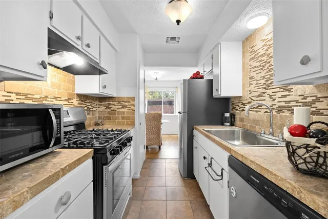 a kitchen with stainless steel appliances granite countertop a sink stove and cabinets