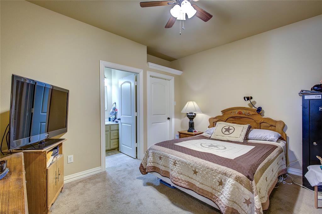 1066 Canyon Lake Road Wills Point, TX 75169 - Photo 17 of 40 a bedroom with a bed and a chandelier