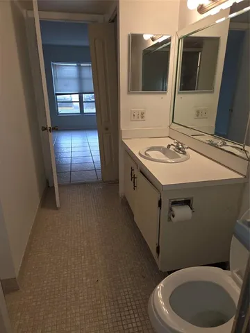 a bathroom with a toilet sink and mirror