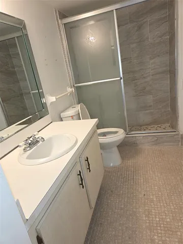 a bathroom with a sink a toilet and shower