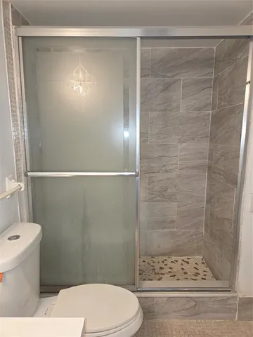 a bathroom with a toilet and a shower