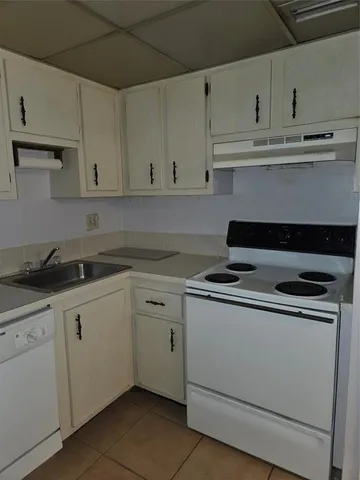 a kitchen with granite countertop white cabinets and a stove