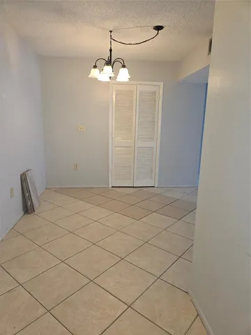 a view of a livingroom with a chandelier fan and glass door