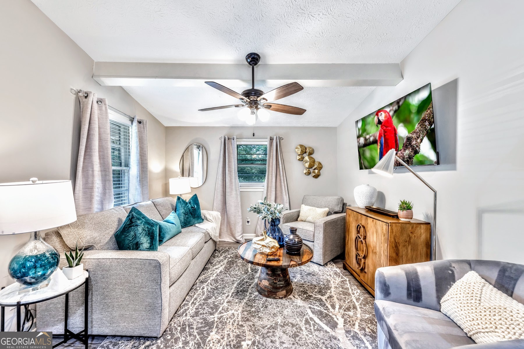 a living room with furniture kitchen view and a large window