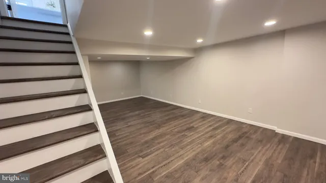 a view of an empty room with wooden floor and entryway