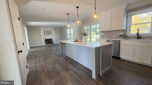 a kitchen with granite countertop a sink a counter space appliances and cabinets