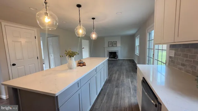 a kitchen with kitchen island a wooden floor and a chandelier
