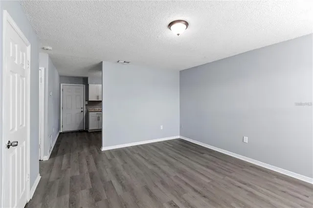 a view of an empty room with wooden floor