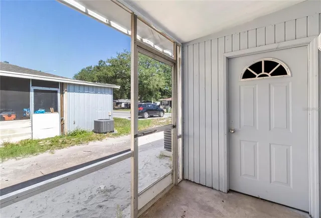 a view of backyard with small cabin and wooden chair