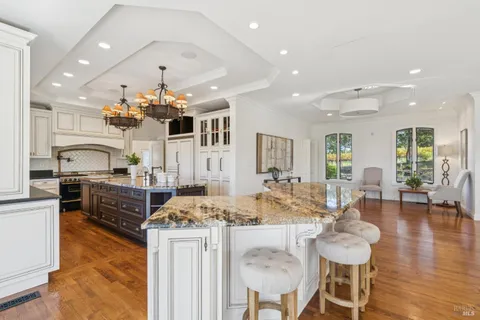 a kitchen with stainless steel appliances kitchen island granite countertop a stove and cabinets