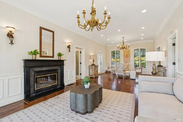 a living room with furniture a fireplace and a floor to ceiling window