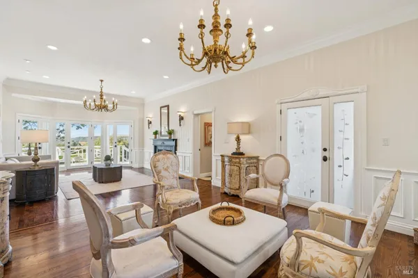 a view of a dining room with furniture a chandelier and wooden floor