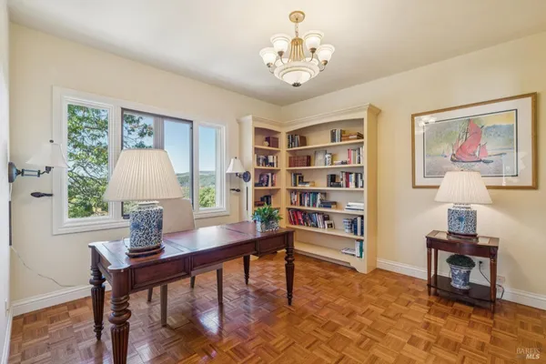 a view of a workspace with furniture and a window
