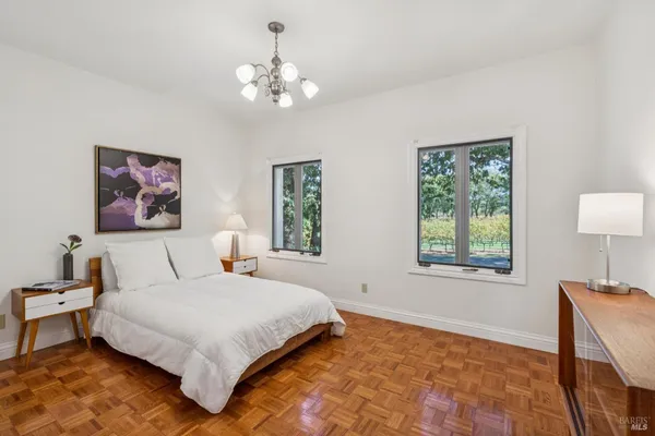 a bedroom with a large bed and a chandelier