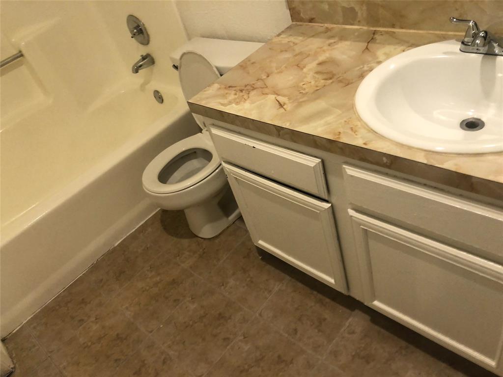 9696 Walnut Street, Unit 2103 Dallas, TX 75243 - Photo 6 of 7 Bathroom featuring a white bathtub, toilet, and a vanity with a cultured marble-look countertop