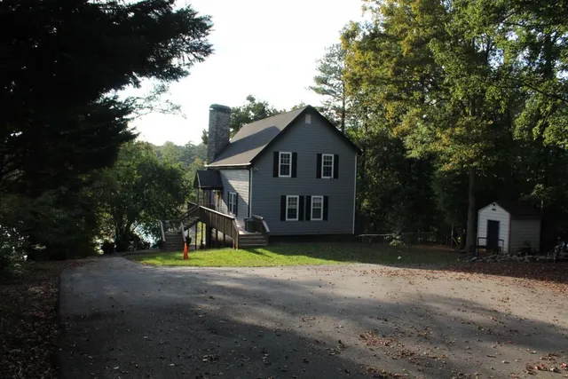 a view of a house with backyard and a tree