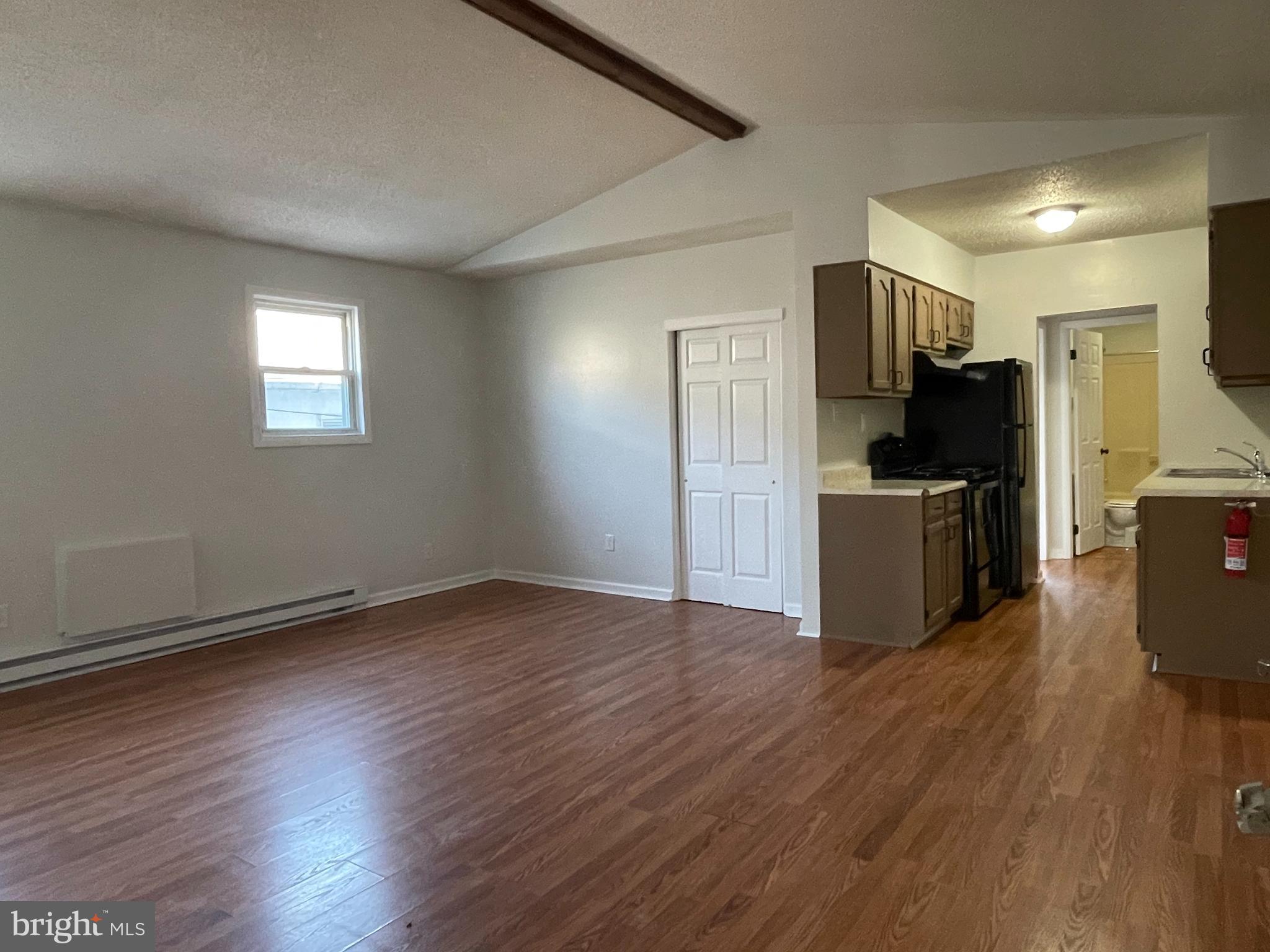 317 Bridge Street, Unit 2 Phoenixville, PA 19460 - Photo 6 of 12 a view of a kitchen with wooden floor and electronic appliances