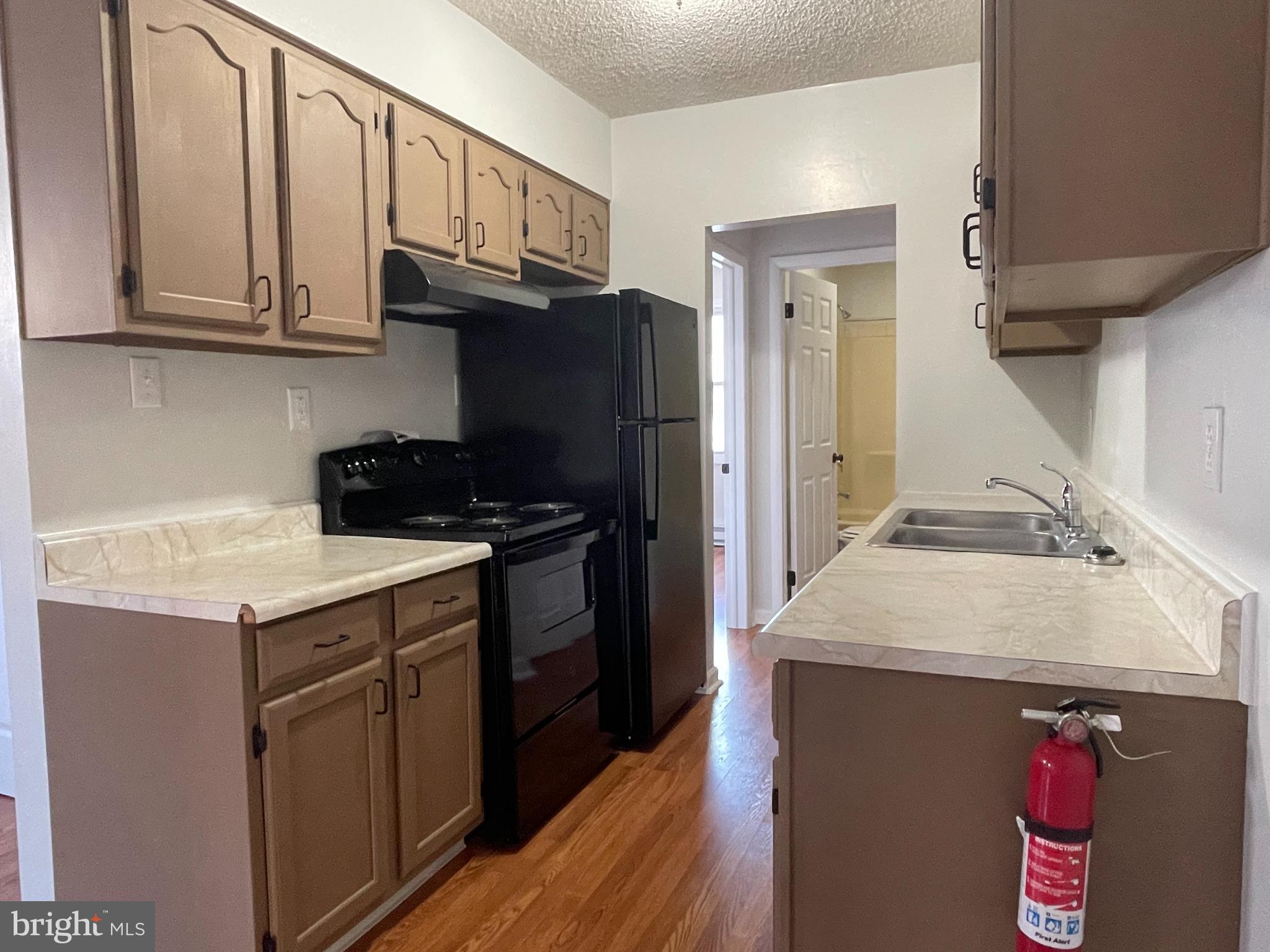 317 Bridge Street, Unit 2 Phoenixville, PA 19460 - Photo 7 of 12 a kitchen with stainless steel appliances granite countertop a sink stove and refrigerator