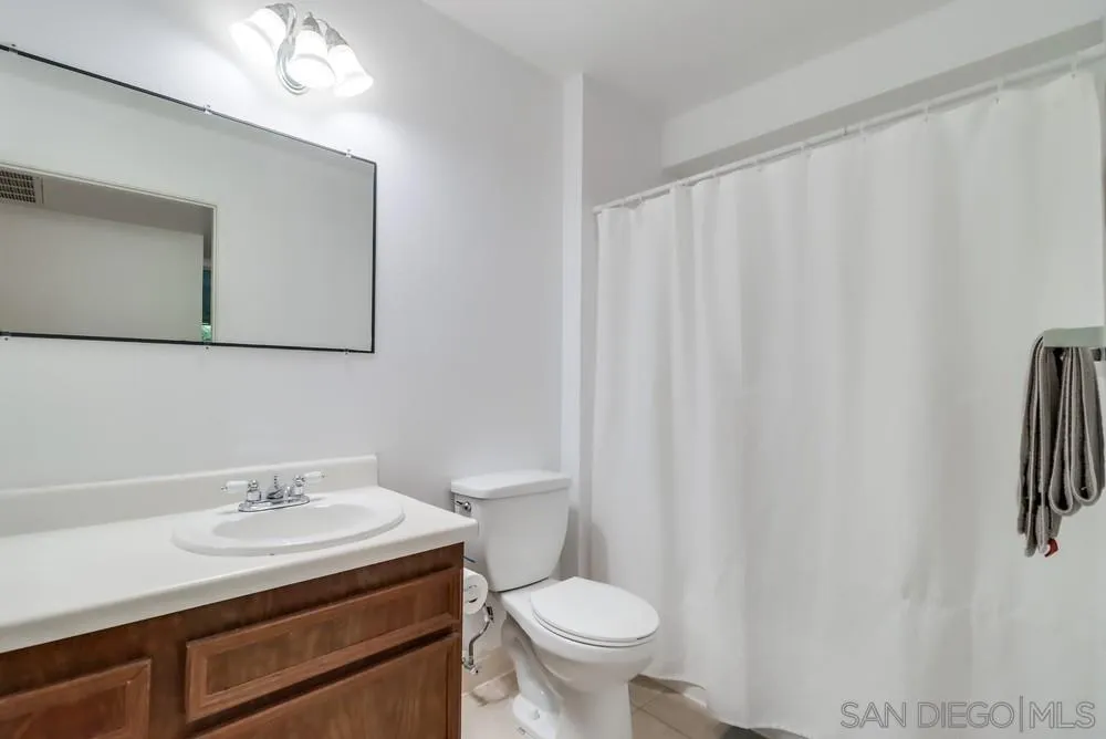 6191 Rancho Mission Road, Unit 105 San Diego, CA 92108 - Photo 11 of 31 a bathroom with a sink toilet and a mirror
