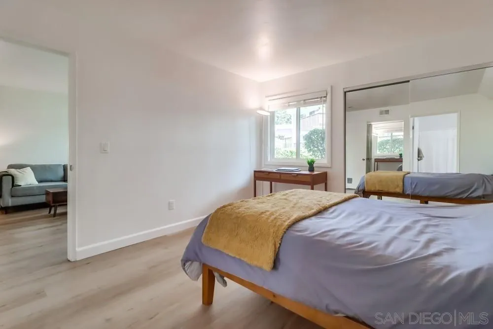 6191 Rancho Mission Road, Unit 105 San Diego, CA 92108 - Photo 13 of 31 a bedroom with a bed and a chair with the wooden floor