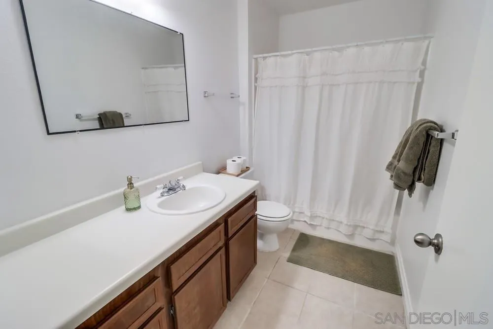 6191 Rancho Mission Road, Unit 105 San Diego, CA 92108 - Photo 15 of 31 a bathroom with a double vanity sink and a mirror