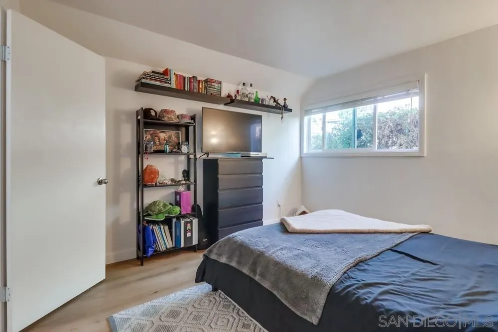 6191 Rancho Mission Road, Unit 105 San Diego, CA 92108 - Photo 16 of 31 a bedroom with a bed and a wooden floor