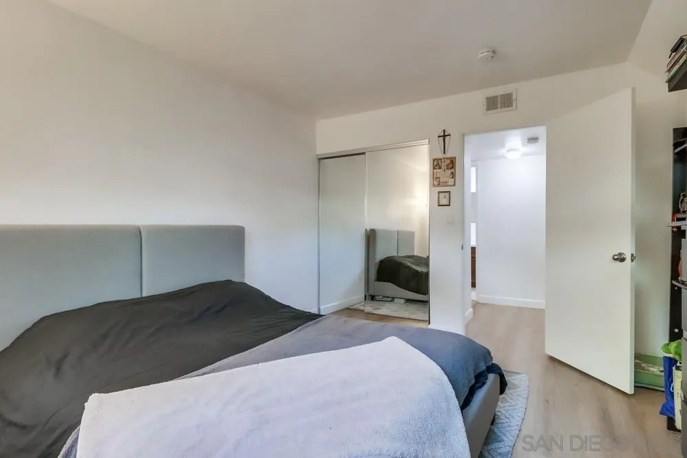 6191 Rancho Mission Road, Unit 105 San Diego, CA 92108 - Photo 17 of 31 a bedroom with a bed and a mirror