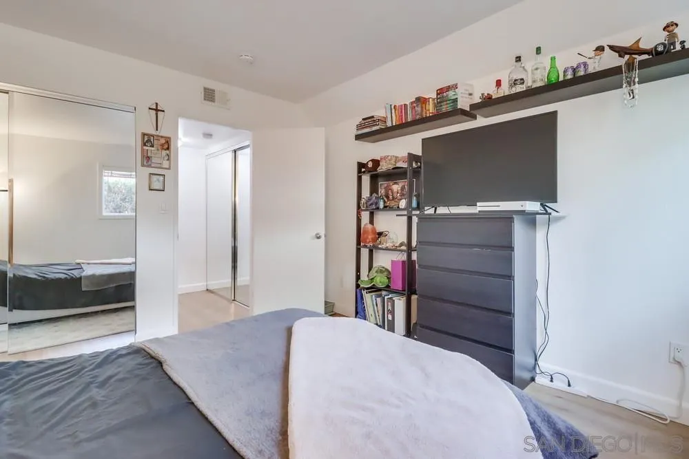 6191 Rancho Mission Road, Unit 105 San Diego, CA 92108 - Photo 18 of 31 a bedroom with a bed and cabinets