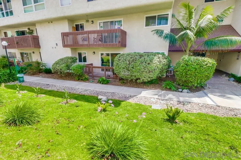 6191 Rancho Mission Road, Unit 105 San Diego, CA 92108 - Photo 24 of 31 a front view of a house with a yard and a garage