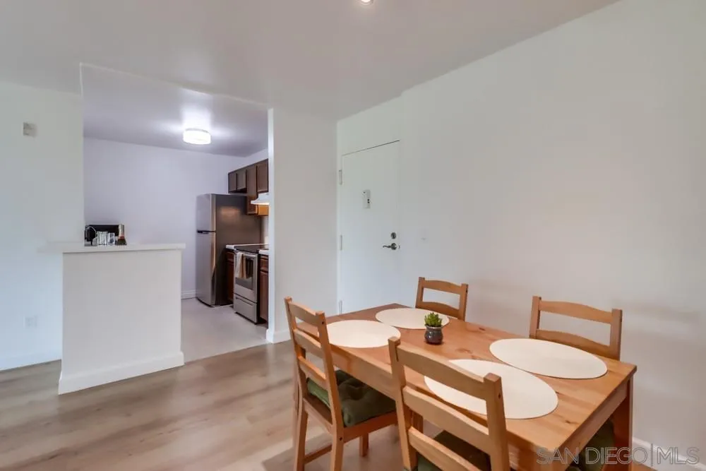 6191 Rancho Mission Road, Unit 105 San Diego, CA 92108 - Photo 7 of 31 a view of a dining room with furniture and wooden floor