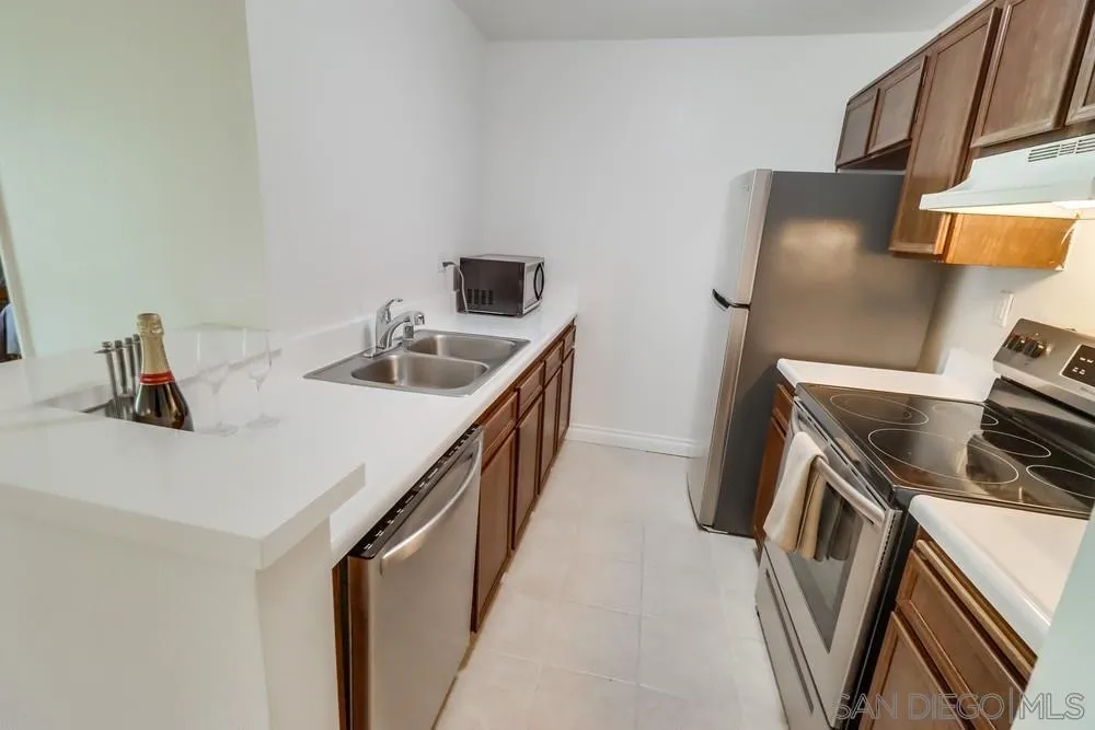 6191 Rancho Mission Road, Unit 105 San Diego, CA 92108 - Photo 8 of 31 a kitchen with stainless steel appliances a sink and a stove