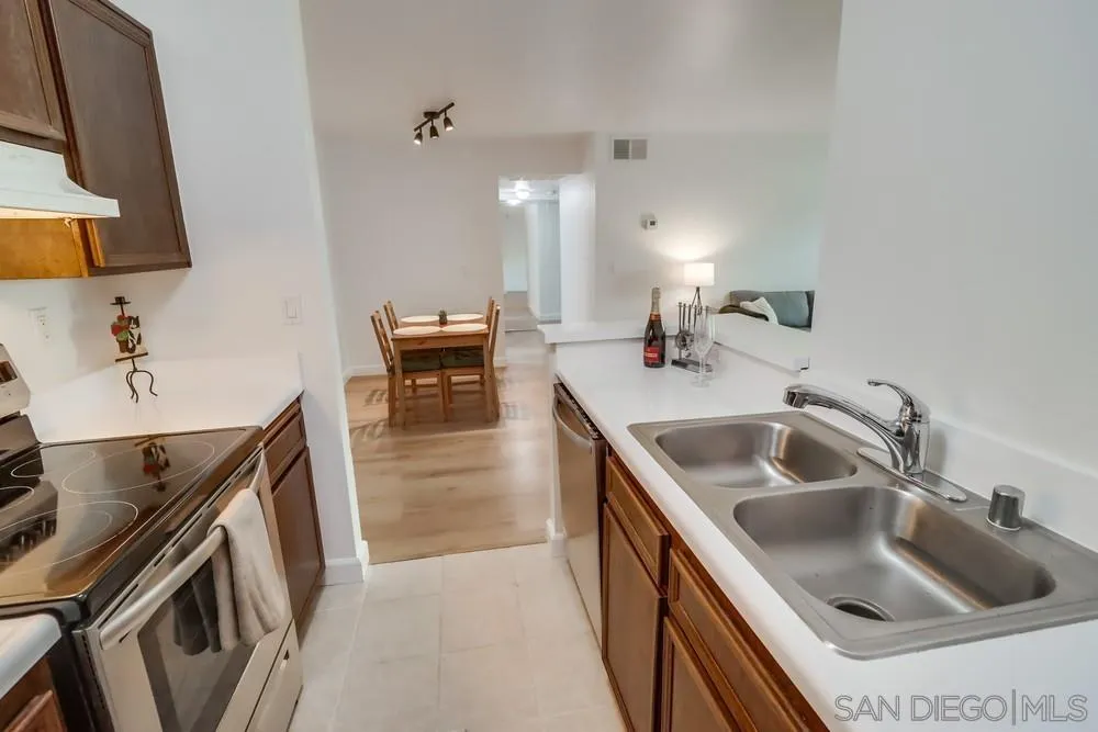 6191 Rancho Mission Road, Unit 105 San Diego, CA 92108 - Photo 10 of 31 a kitchen with sink cabinets and stove