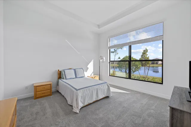 a spacious bedroom with a bed and a large window
