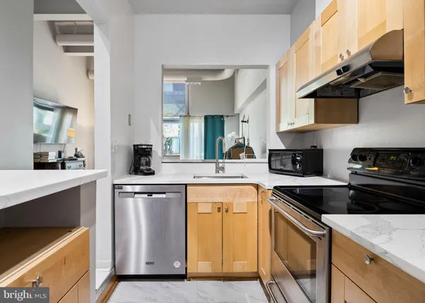 a kitchen with stainless steel appliances granite countertop a sink a stove and cabinets